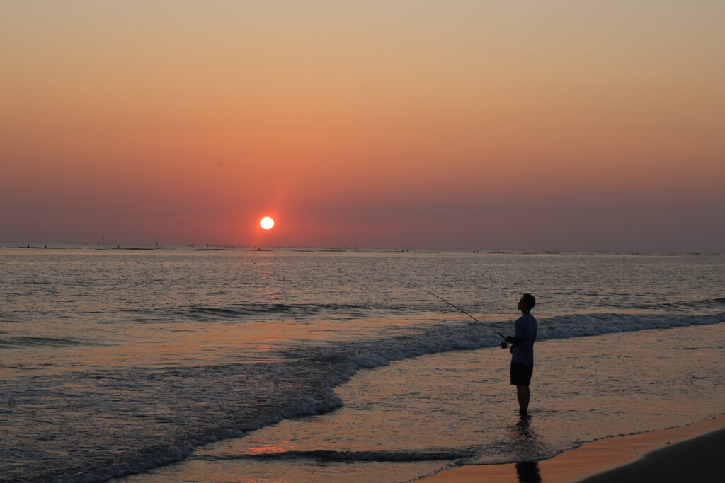 Student standing on a beach