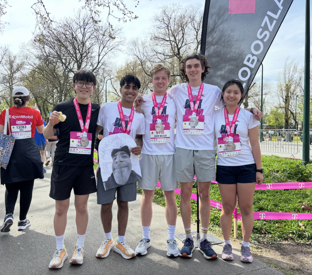 Arnav with friends wearing medals at the end of a running race