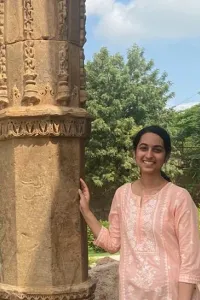 Student standing next to pillars at the Qutub Minar