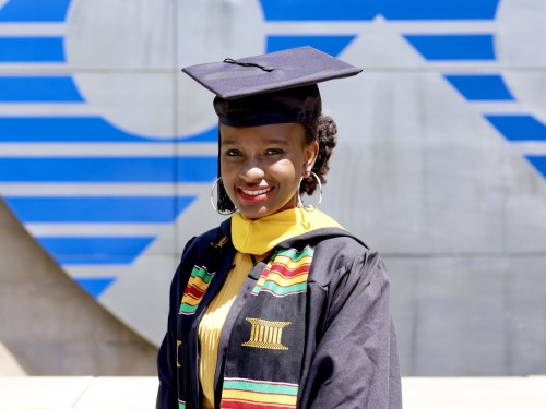 Nyasha Zimunhu standing on Perelman Quad in graduation regalia