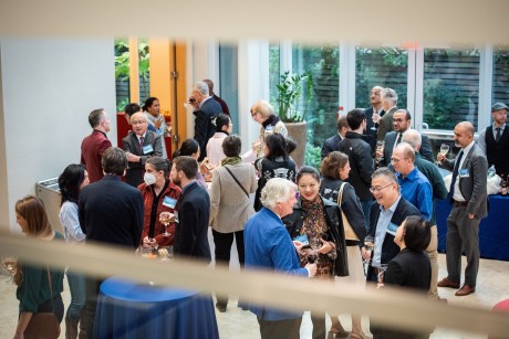 Guests gather and mingle over food and drink in the World Forum at Perry World House. 