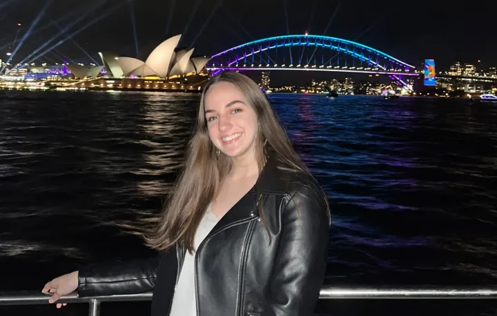 Student standing in front of bay with Sydney Opera House in the background