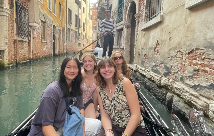 Students riding a boat in a river in a city