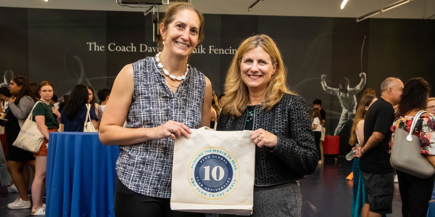 President Liz Magill and AVP Amy Gadsden holding a Penn Global 10th aniversary tote bag at the ISO welcome picnic 2022