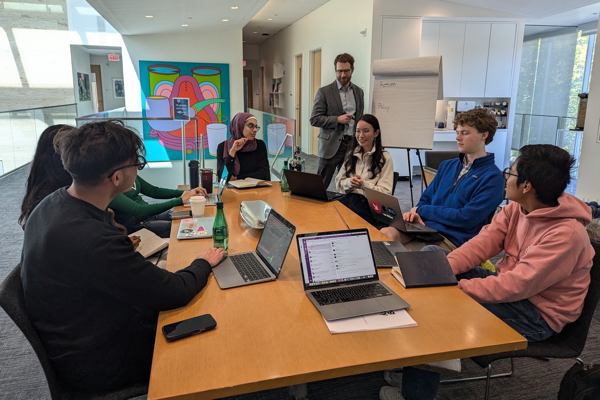 A team of Perry World House Student Fellows discuss actions and policies during the 2024 crisis simulation at Perry World House, facilitated by Tom Ellison (standing), deputy director of the Center for Climate and Security at the Council on Strategic Risks. (Image: Courtesy of Perry World House)