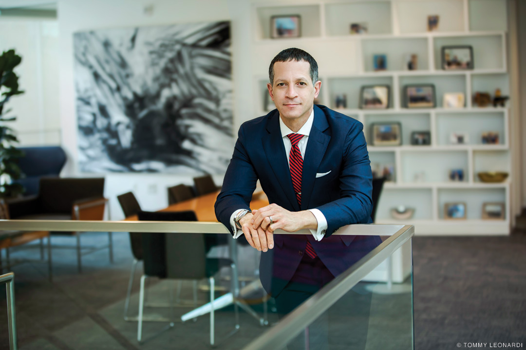 Profile shot of Michael Horowitz, dressed in a blue suit and red tie on the top floor of Perry World House.